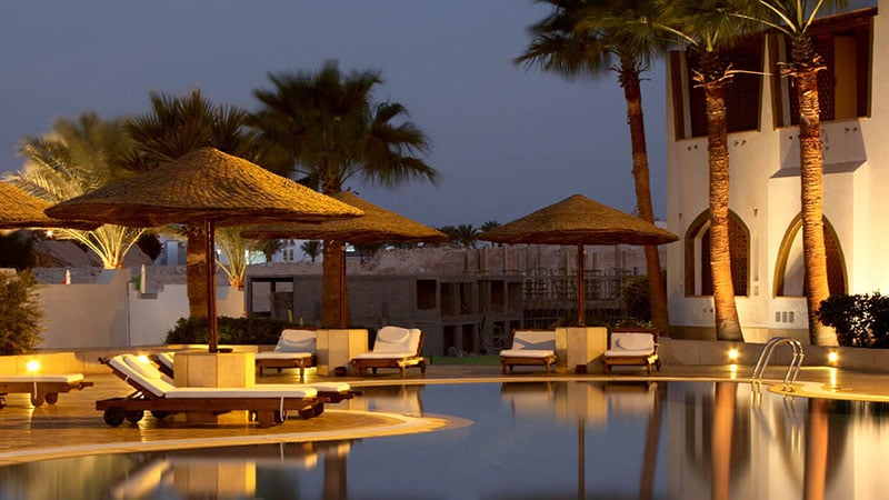 A pool with umbrellas and lounge chairs