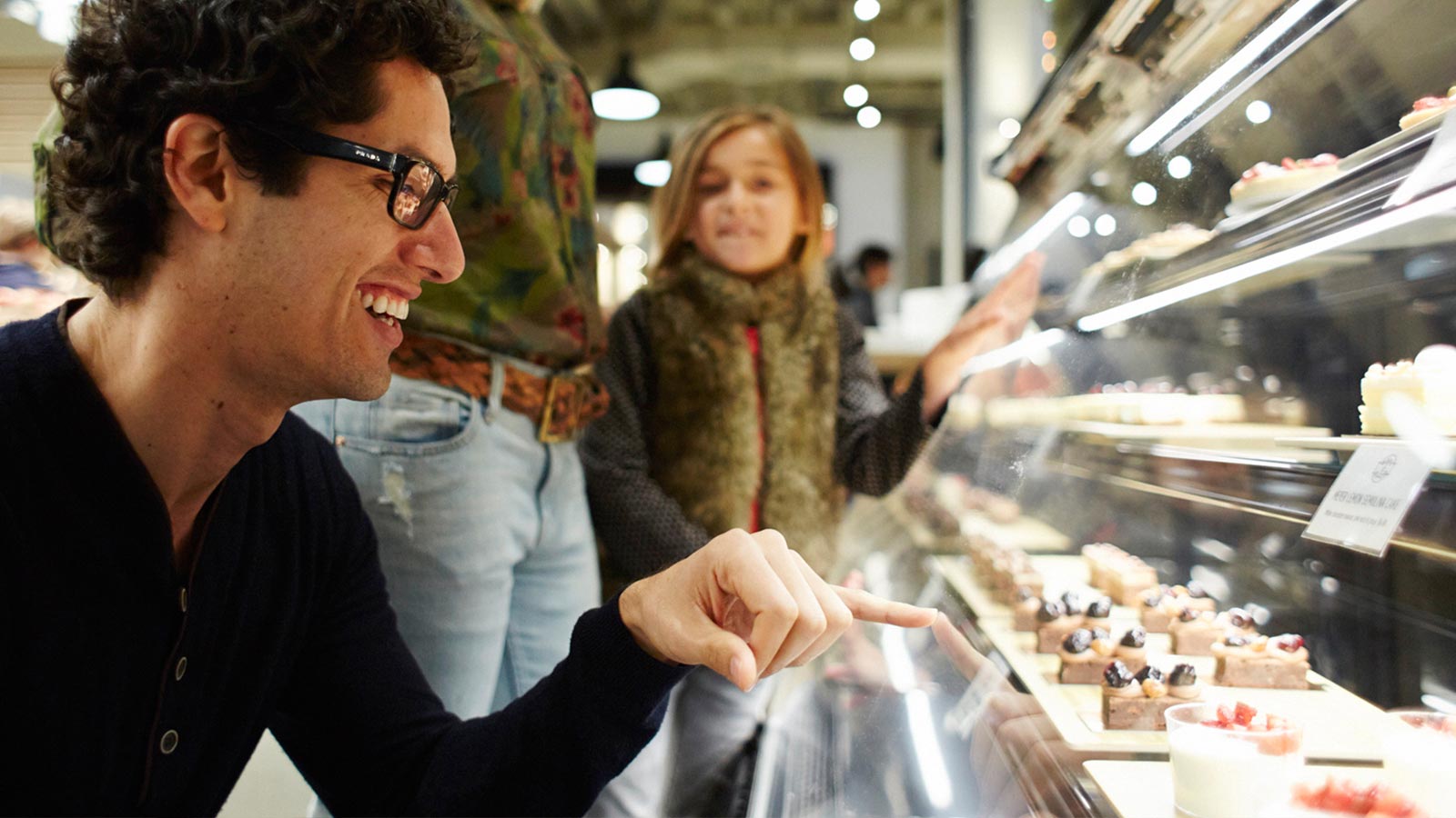 A family looking at pastries through the display glass.