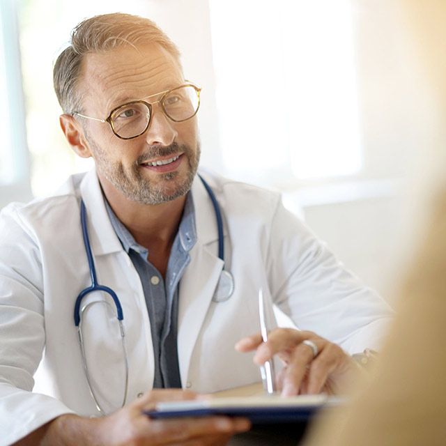 A smiling doctor with a phonendoscope around his neck