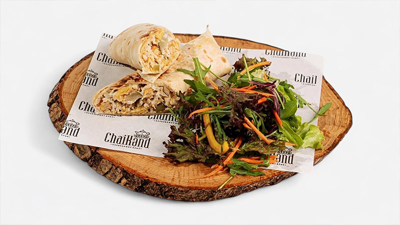 Fresh wrap sandwich served with a mixed green salad.